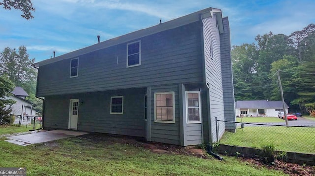 back of house with a yard and a patio