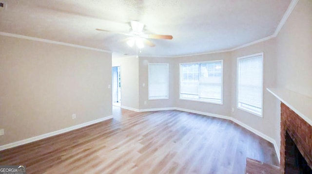 unfurnished living room featuring a textured ceiling, a fireplace, ceiling fan, light hardwood / wood-style floors, and crown molding