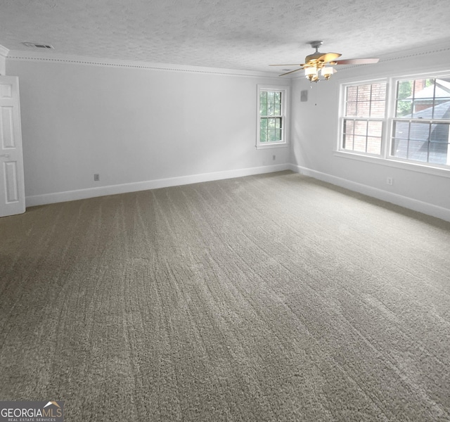 carpeted empty room featuring ceiling fan, crown molding, and a textured ceiling