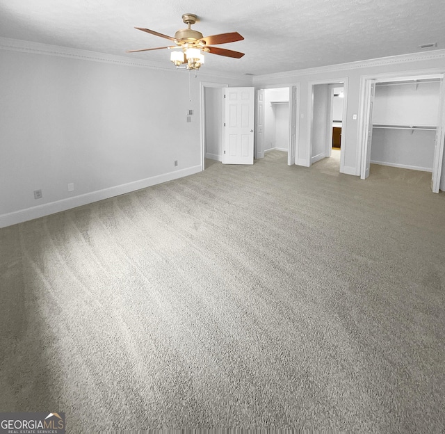 unfurnished bedroom with carpet, a textured ceiling, ceiling fan, and crown molding