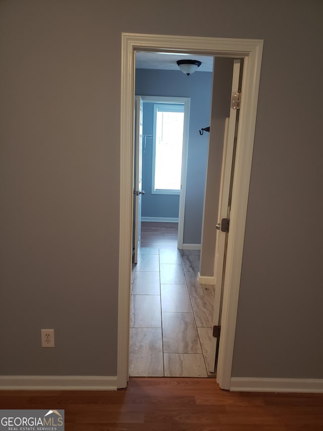 hall with tile patterned floors