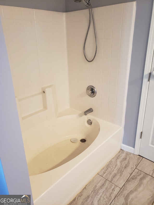 bathroom with tiled shower / bath combo and tile patterned flooring