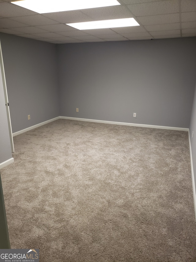 spare room featuring a drop ceiling and carpet