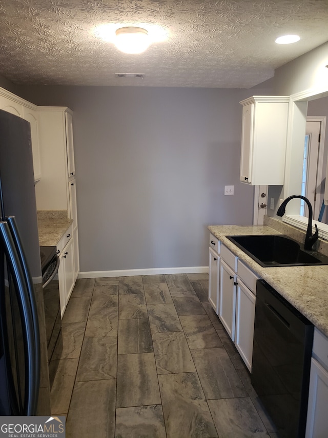 kitchen featuring sink, black appliances, a textured ceiling, and white cabinets