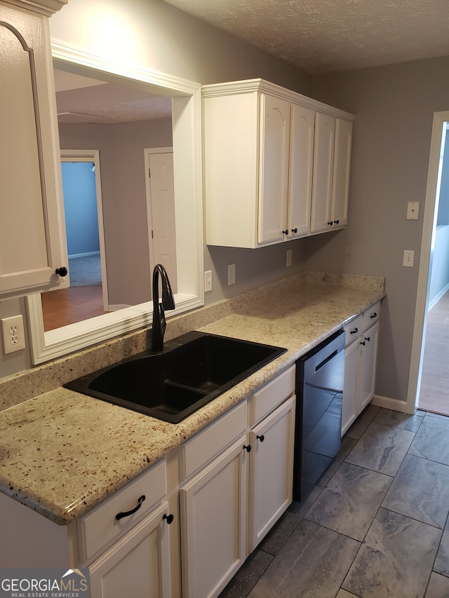 kitchen featuring white cabinets, dishwasher, tile patterned floors, light stone countertops, and sink