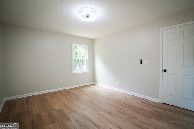 spare room featuring hardwood / wood-style floors and a textured ceiling