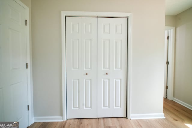 unfurnished bedroom featuring a closet, a textured ceiling, and light wood-type flooring