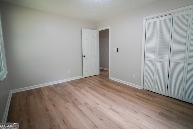 bathroom featuring hardwood / wood-style flooring, toilet, vanity, and a textured ceiling