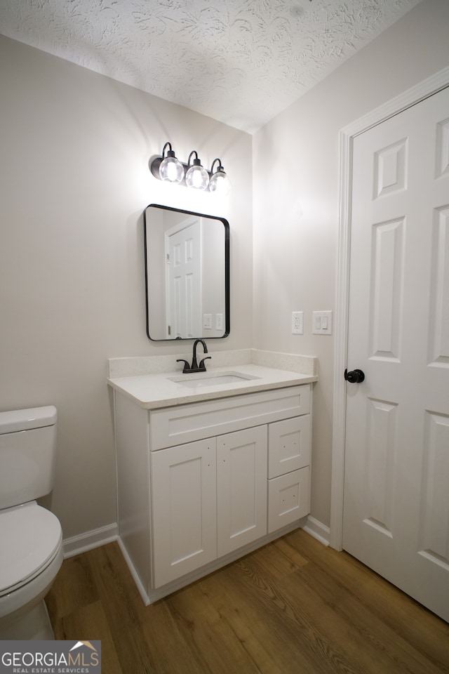 spare room featuring hardwood / wood-style floors and a textured ceiling