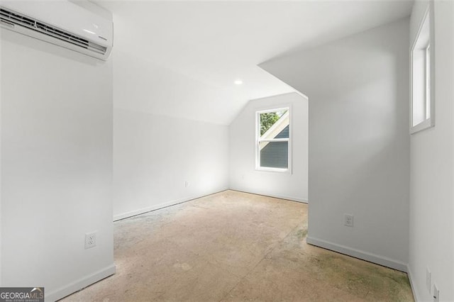 additional living space featuring vaulted ceiling and a wall mounted AC