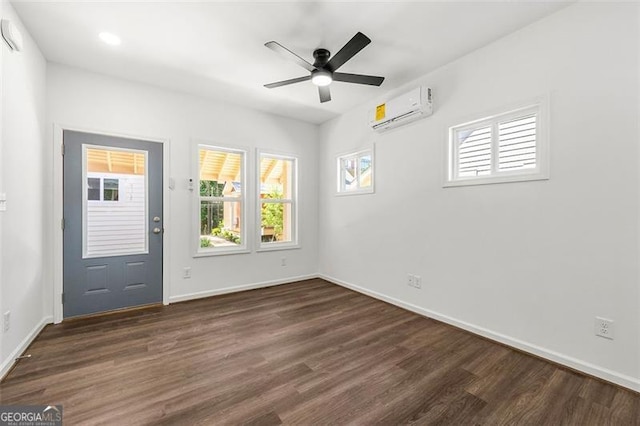 empty room with dark wood-type flooring, ceiling fan, and a wall mounted AC