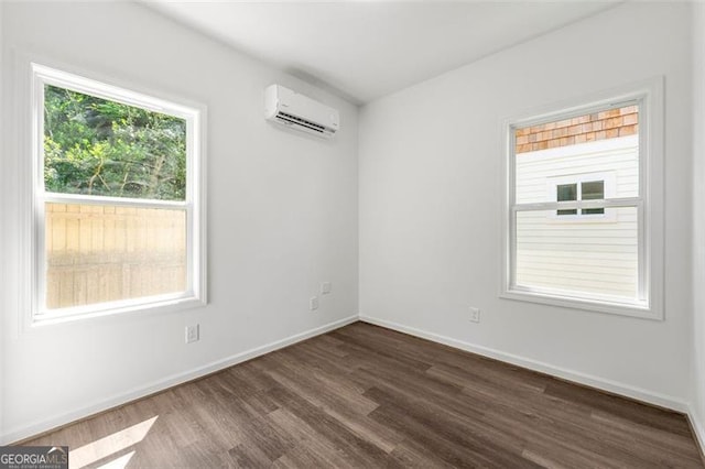 spare room with dark wood-type flooring and a wall mounted AC