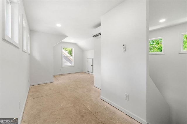 additional living space featuring lofted ceiling and a wall mounted AC