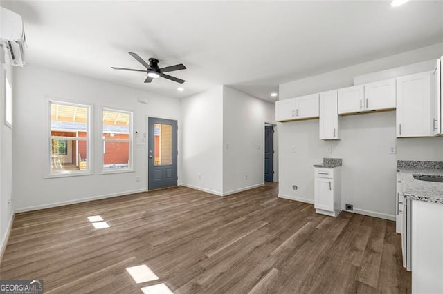 kitchen featuring white cabinetry, ceiling fan, dark hardwood / wood-style floors, and light stone countertops