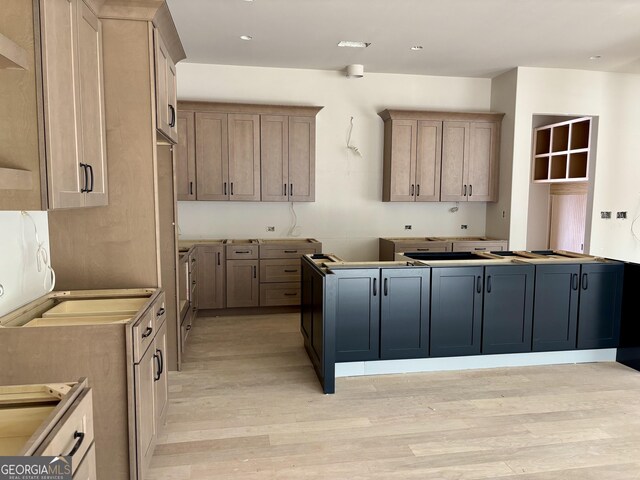 kitchen with light brown cabinetry and light hardwood / wood-style flooring