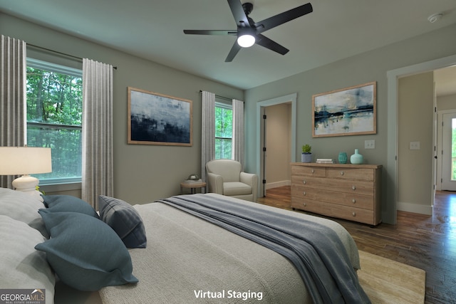 bedroom featuring multiple windows, dark hardwood / wood-style flooring, and ceiling fan