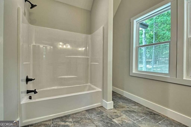 bathroom featuring lofted ceiling, a healthy amount of sunlight, tile patterned floors, and bathtub / shower combination