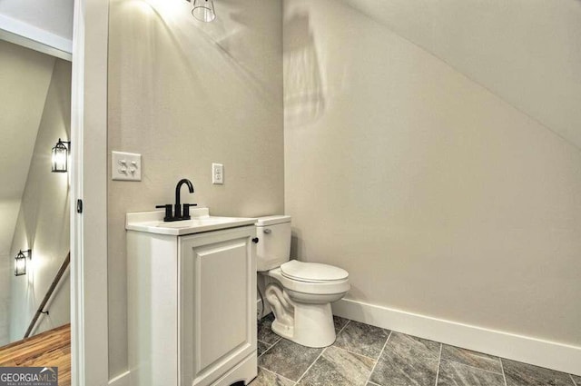 bathroom with vanity, tile patterned floors, lofted ceiling, and toilet