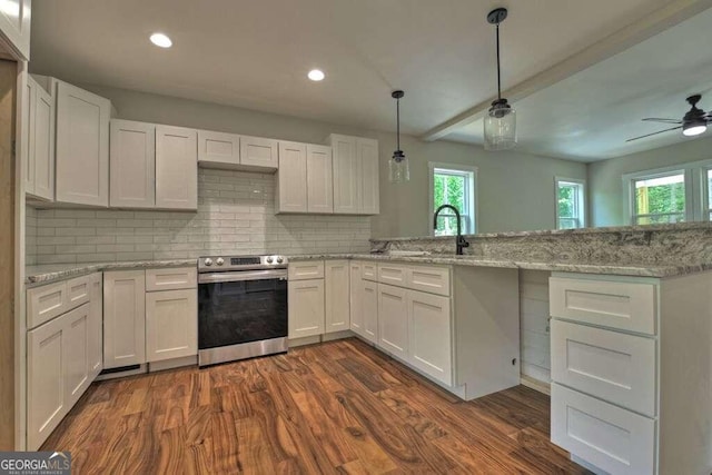 kitchen with kitchen peninsula, dark hardwood / wood-style flooring, ceiling fan, stainless steel range with electric cooktop, and pendant lighting