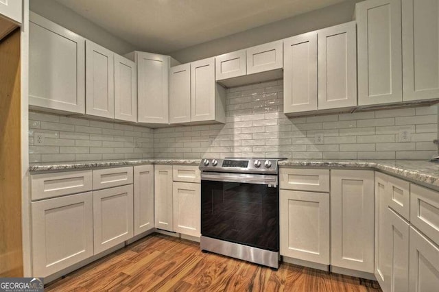 kitchen with stainless steel electric range oven, tasteful backsplash, hardwood / wood-style floors, and white cabinetry