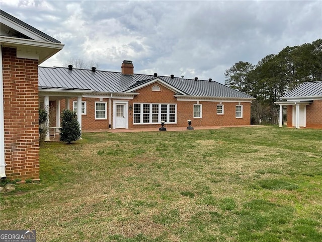 rear view of house featuring a yard