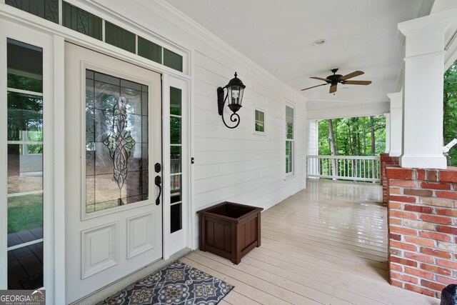 doorway to property featuring covered porch and ceiling fan