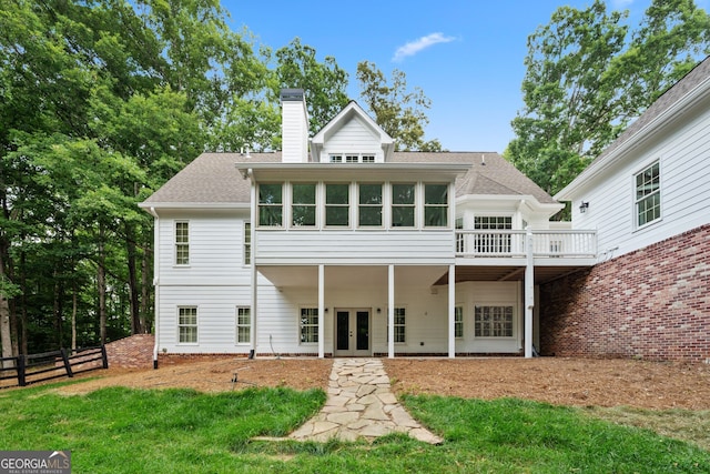 rear view of property featuring a yard and a deck