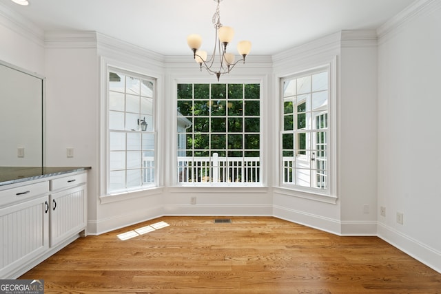 unfurnished dining area featuring light hardwood / wood-style flooring, ornamental molding, and plenty of natural light