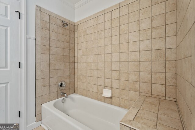 bathroom with ornamental molding and tiled shower / bath