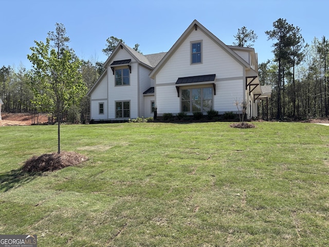 view of front of property with a standing seam roof, metal roof, and a front yard