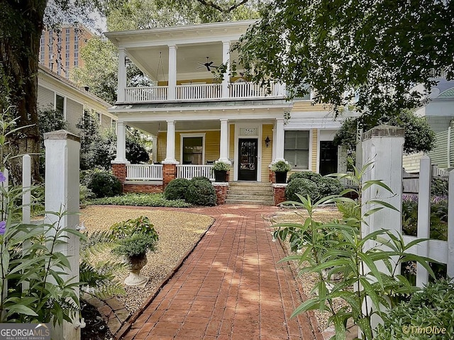 view of front of home featuring ceiling fan and a balcony