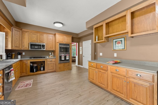 kitchen featuring light wood-type flooring, stainless steel appliances, and sink