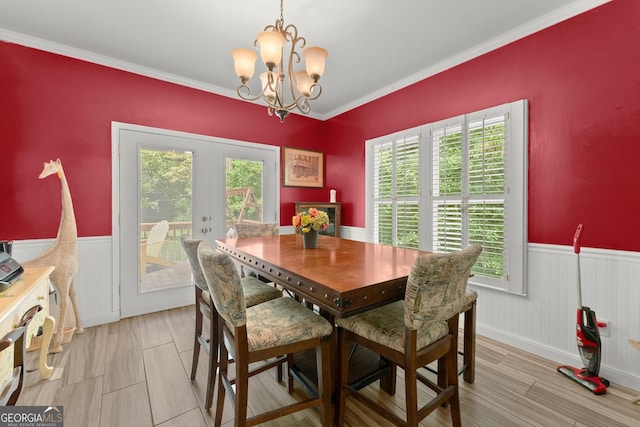 dining space featuring ornamental molding, a notable chandelier, and french doors