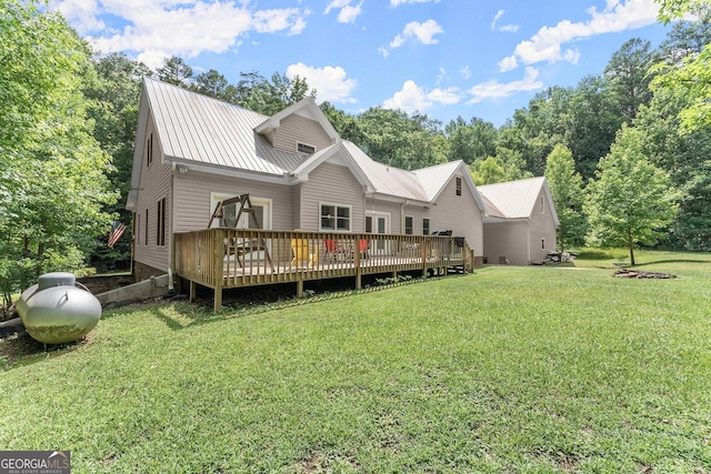 rear view of property with a deck and a lawn