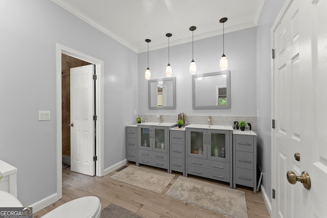 bathroom with hardwood / wood-style floors, toilet, vanity, and crown molding