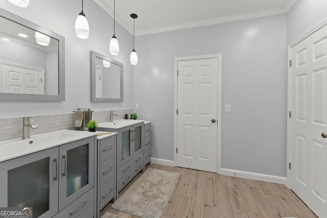 bathroom featuring vanity, crown molding, decorative backsplash, and hardwood / wood-style floors