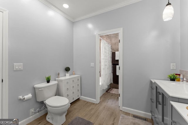 bathroom with hardwood / wood-style floors, toilet, vanity, and ornamental molding