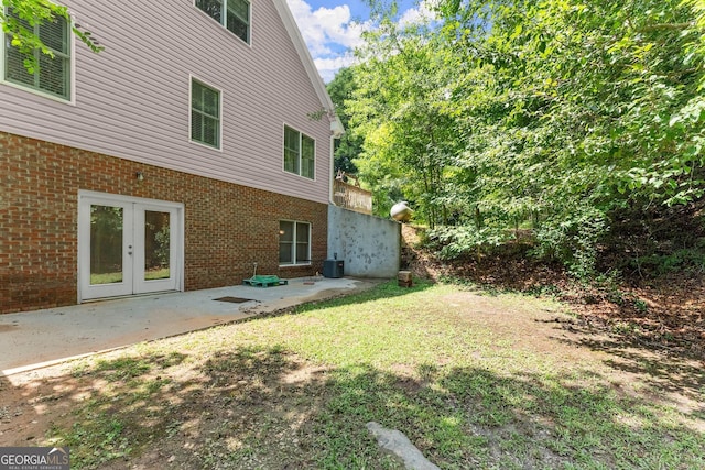 view of yard with a patio, french doors, and central AC