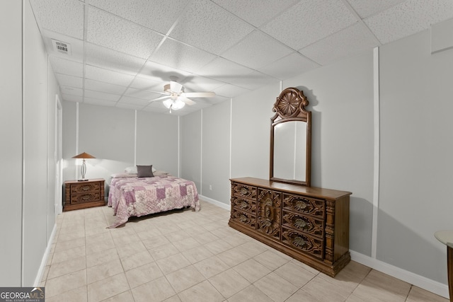 tiled bedroom featuring a drop ceiling and ceiling fan