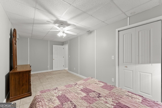 bedroom featuring a drop ceiling, a closet, and ceiling fan