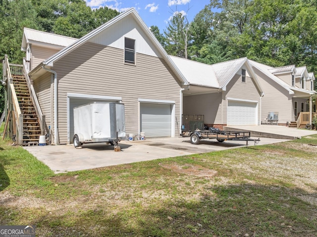 back of property featuring a lawn and a garage