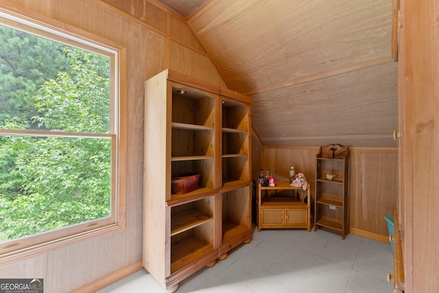 bonus room with wooden ceiling, vaulted ceiling, and wooden walls