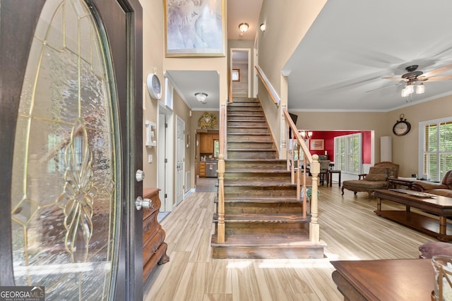 entrance foyer with ceiling fan, light hardwood / wood-style flooring, and ornamental molding