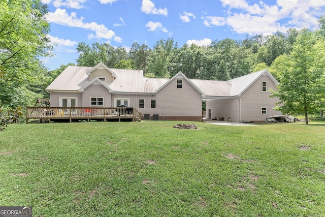 rear view of property with a yard and a deck