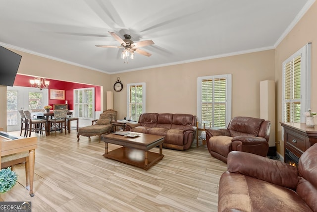 living room with ceiling fan with notable chandelier, a wealth of natural light, and ornamental molding