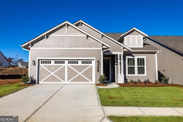 craftsman house with a garage and a front lawn