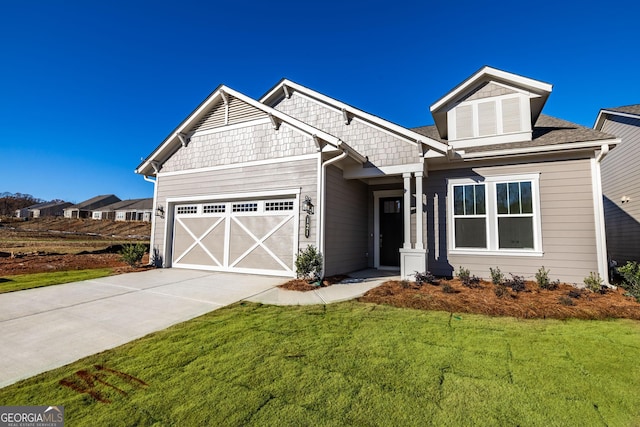 craftsman house with a front yard and a garage