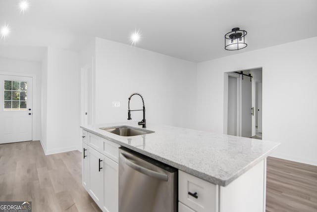 kitchen with white cabinets, sink, a barn door, dishwasher, and an island with sink