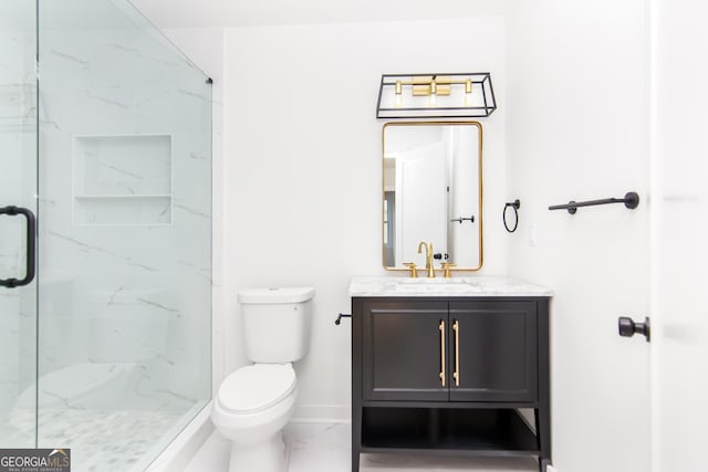 bathroom with vanity, a shower with shower door, and toilet