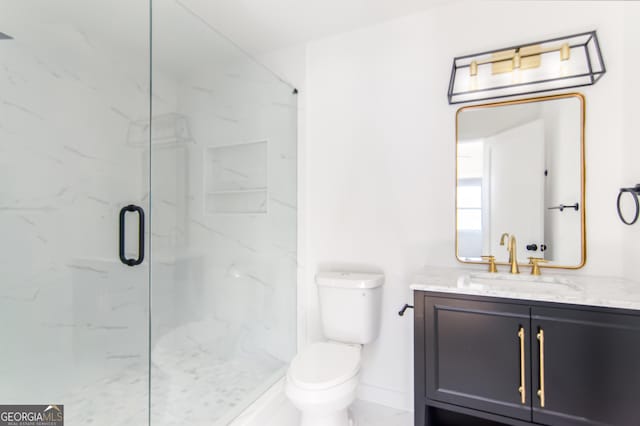 bathroom featuring an enclosed shower, vanity, and toilet